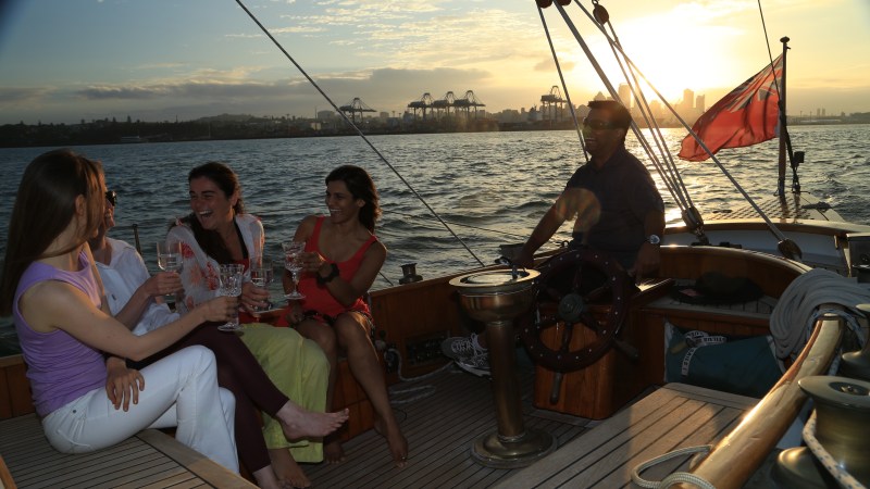 Group of people having drinks on a boat during sunset